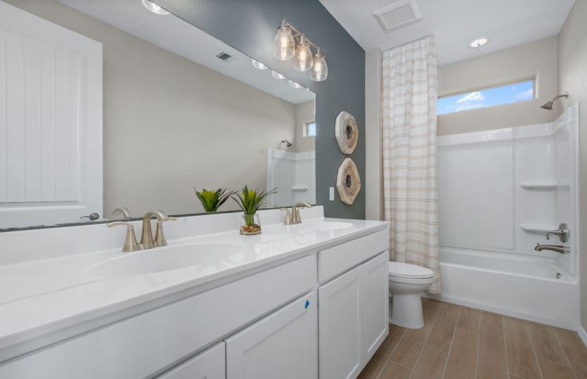 The secondary bath upstairs includes a shower/tub combo and dual sink vanity.