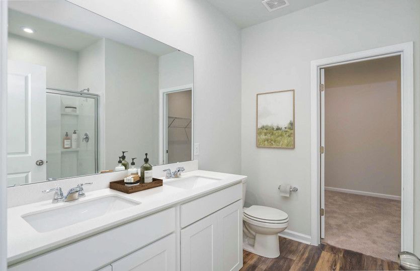 Owner's suite bath with dual vanities and a spacious walk-in closet.