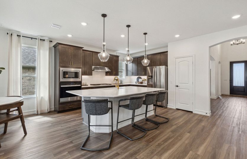 Spacious kitchen with recessed and pendant lighting