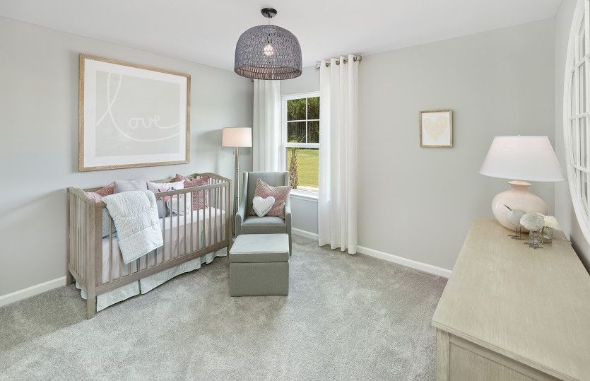 Bright and cozy secondary bedroom with decorative light fixture.