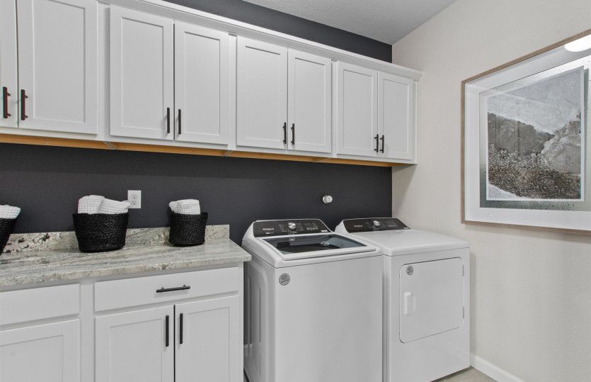 Laundry room with cabinets for additional storage space.