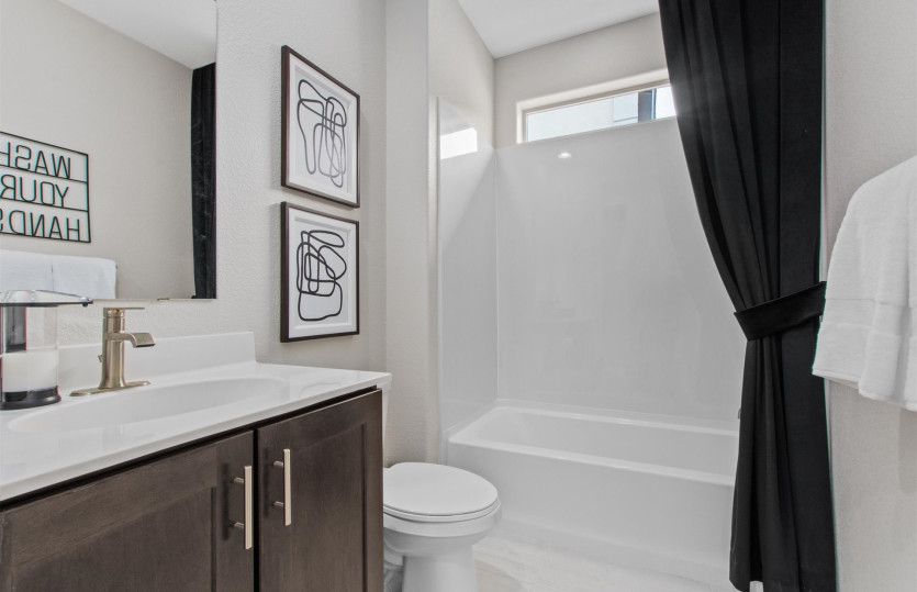 Guest bathroom complete with cultured marble counters and a combined bath tub and shower configurati