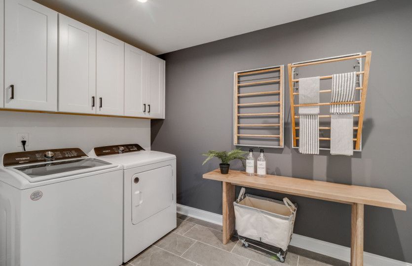 The well-equipped laundry room, complete with ample cabinets, offers both functionality and organiza