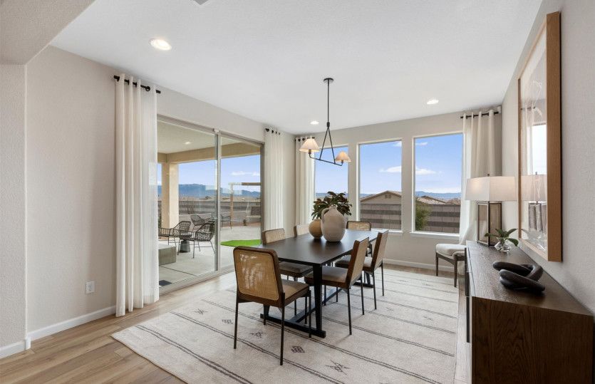 Overhead accent lighting fixtures, large windows, and a sliding glass door accent provide modern bea