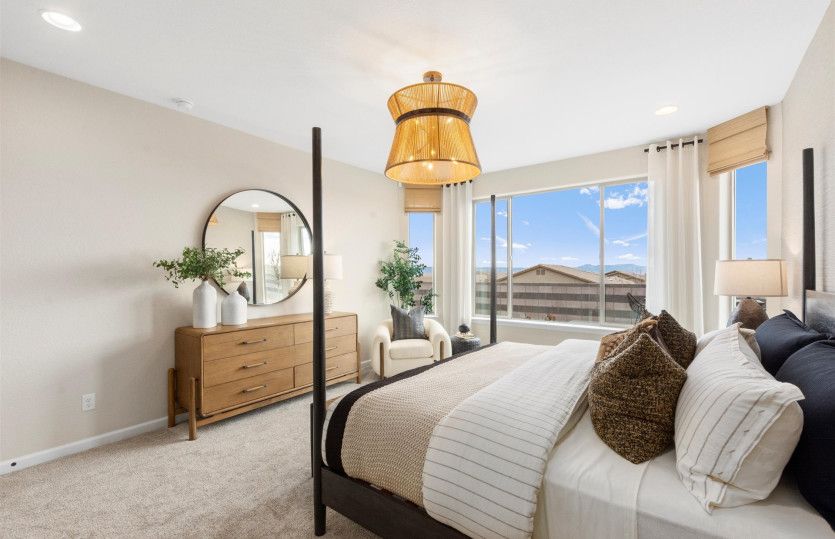 Owner's suite shown with a large bed and cozy accent chair.