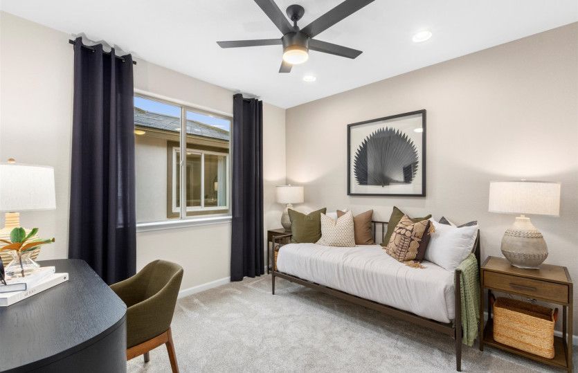 Guest bedroom features a large window for plenty of natural light.