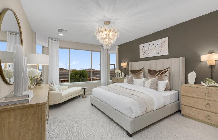 Relaxing owner's suite with bright bay windows and decorative ceiling light fixture.
