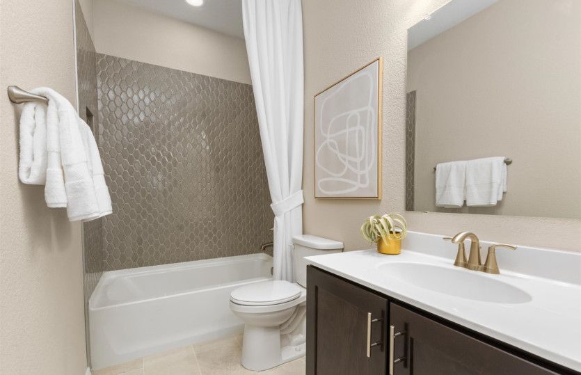 Upstairs bathroom with tile surrounding the shower and bath.