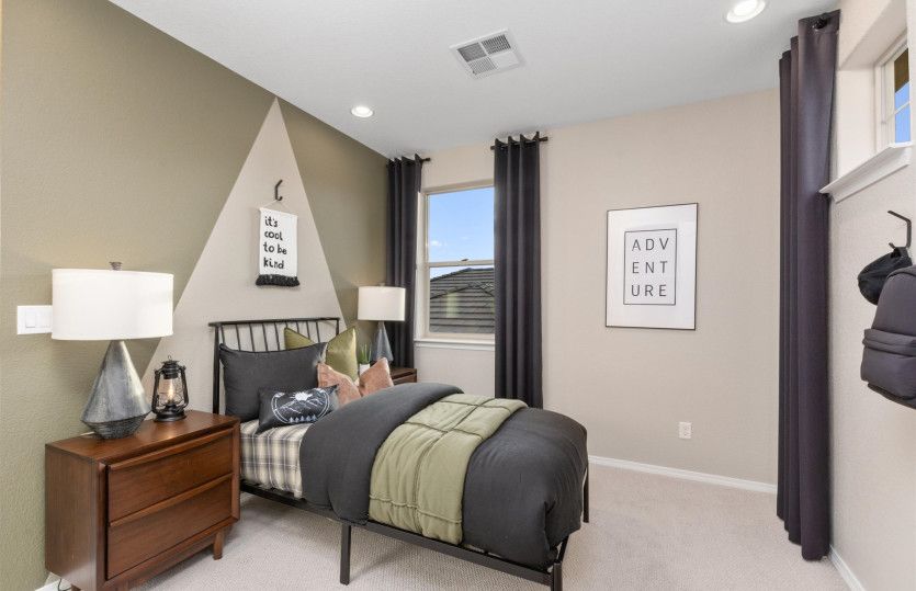 Fourth bedroom upstairs features cozy carpeting, two-tone paint detail and a walk-in closet.