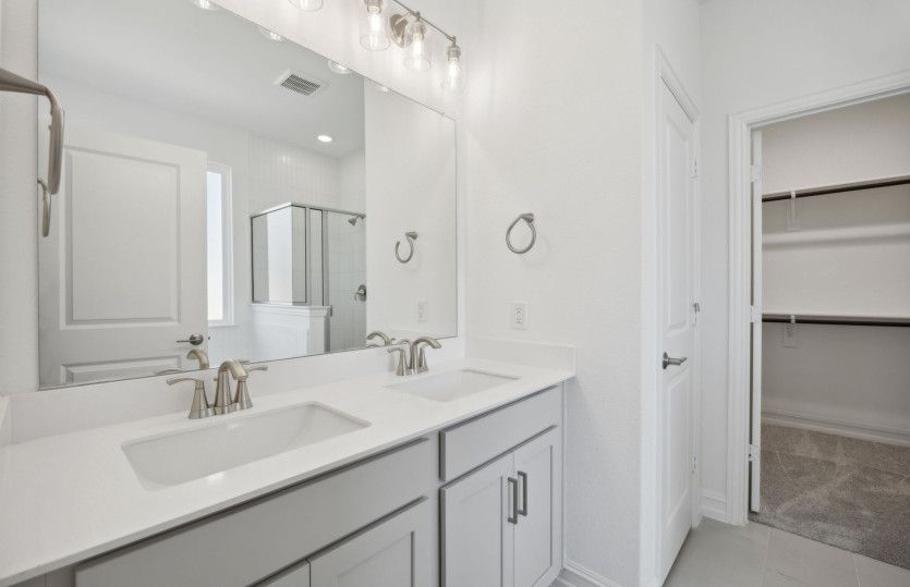 Elegant owner's bathroom with dual vanity and oversized shower *model representation