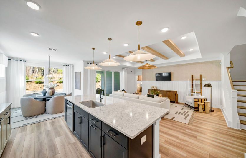 Gourmet Kitchen with decorative lighting with white cabinets and a dark island.