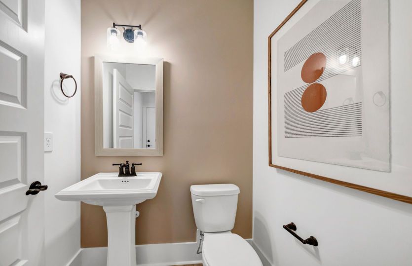 A cozy downstairs powder room featuring elegant fixtures and a warm ambiance