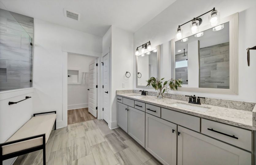 Beautiful Owner's Bath equipped with  framed mirrors and a large walk-in shower.