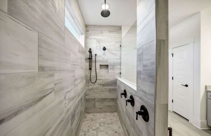 The en-suite bathroom showcases the walk-in shower with a rainfall shower head and modern fixtures.