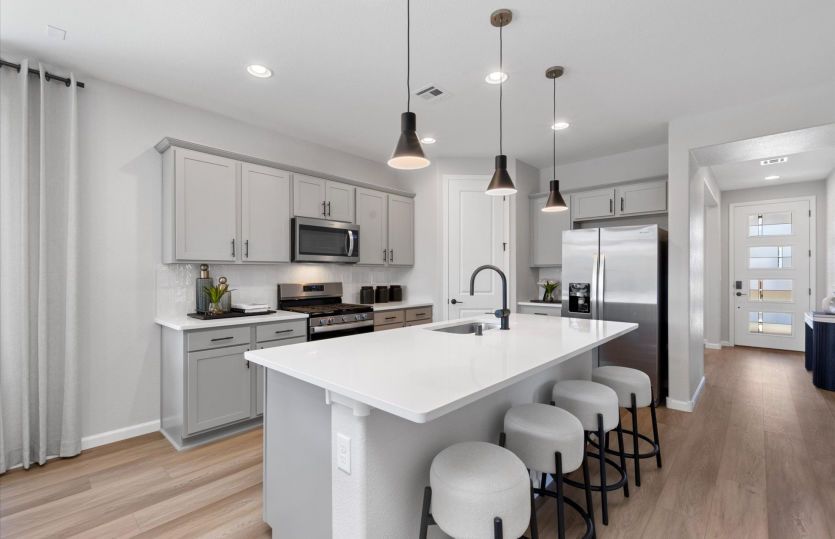 Bright and open kitchen in the Hewitt accented with pendant lights over the kitchen island.