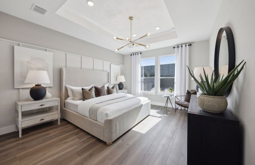 Spacious primary suite with large windows and private bath *model representation