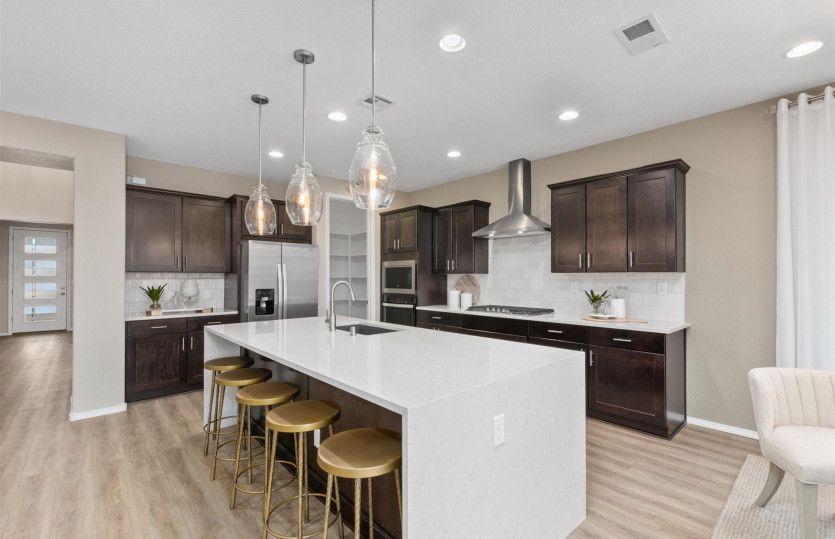 Enjoy a chef's kitchen with built-in stainless-steel appliances and hanging pendant lights abouve th