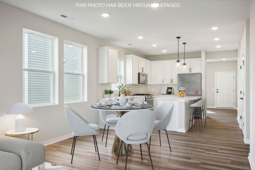 Standing in the gathering and dining room areas looking into the beautiful kitchen