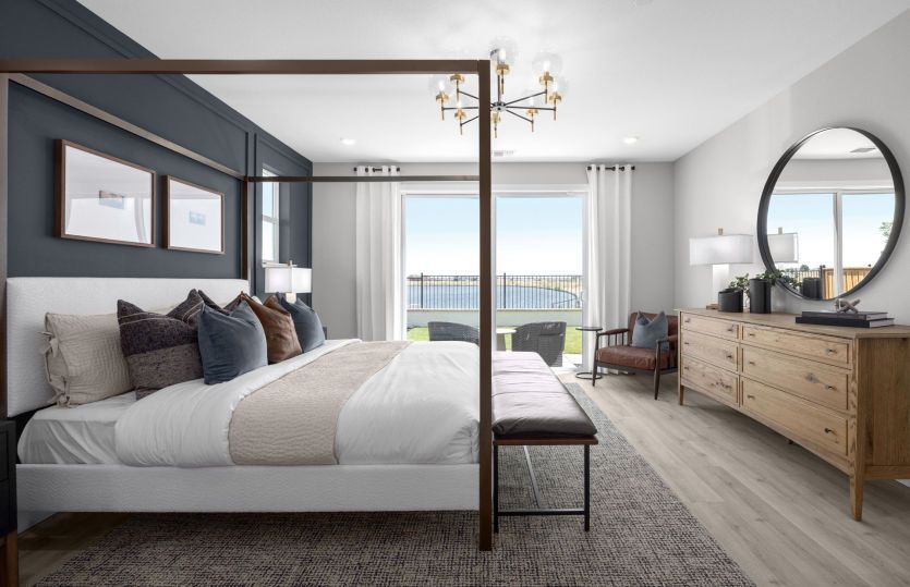 Primary bedroom suite with lake views and balcony access