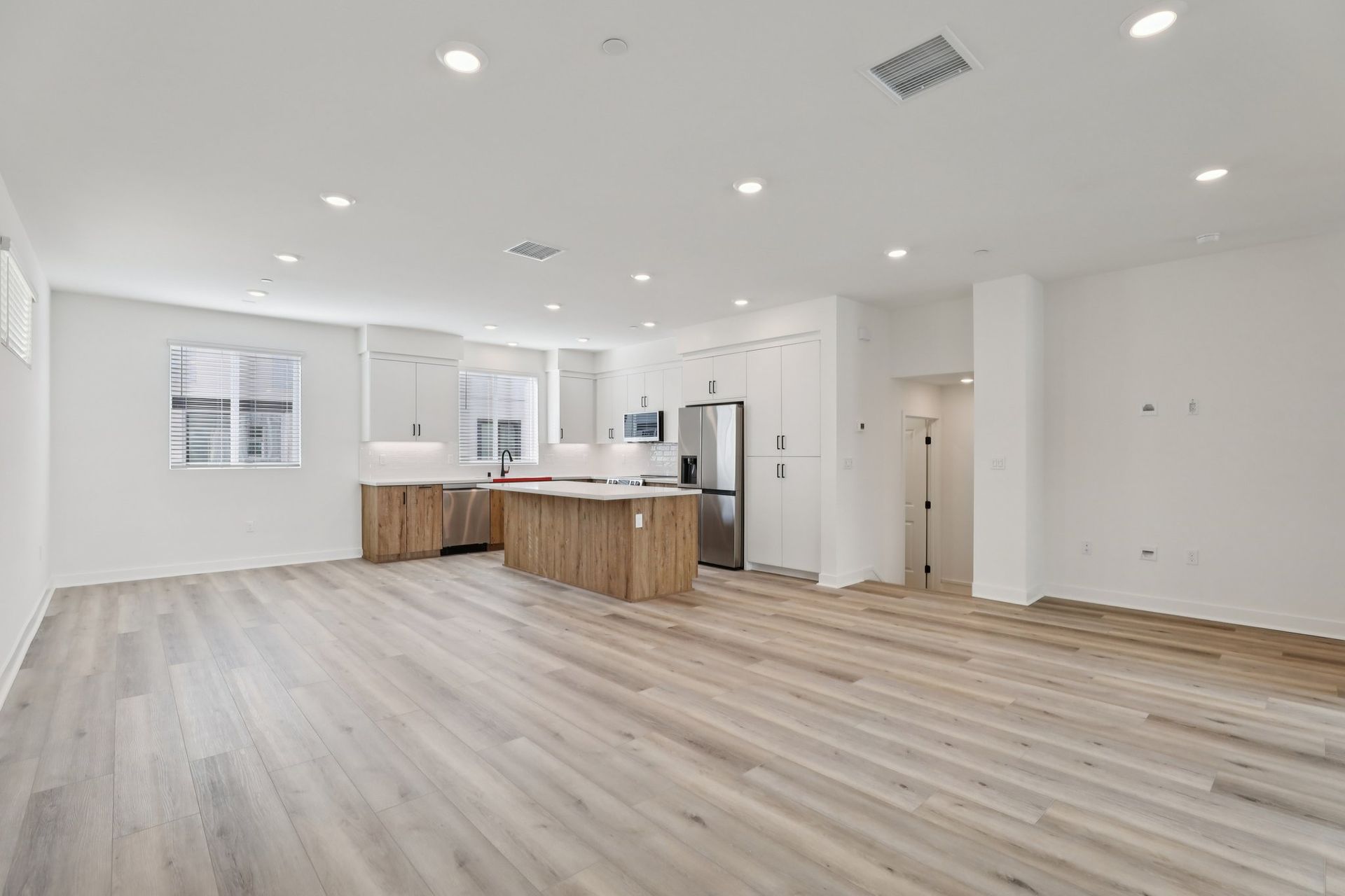 Spacious great room with upgraded flooring, window treatments, and stunning deck