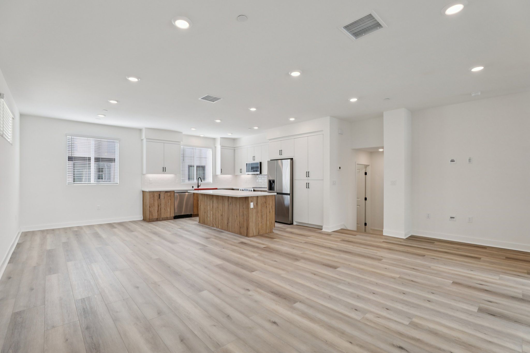 Spacious great room with upgraded flooring, window treatments, and stunning deck
