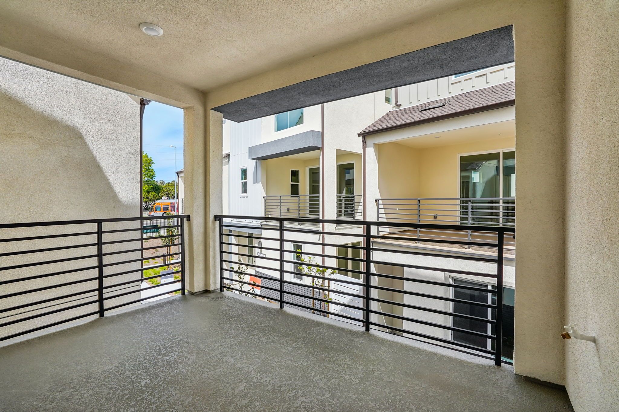 Covered deck with seating area and sliding doors offering neighborhood views