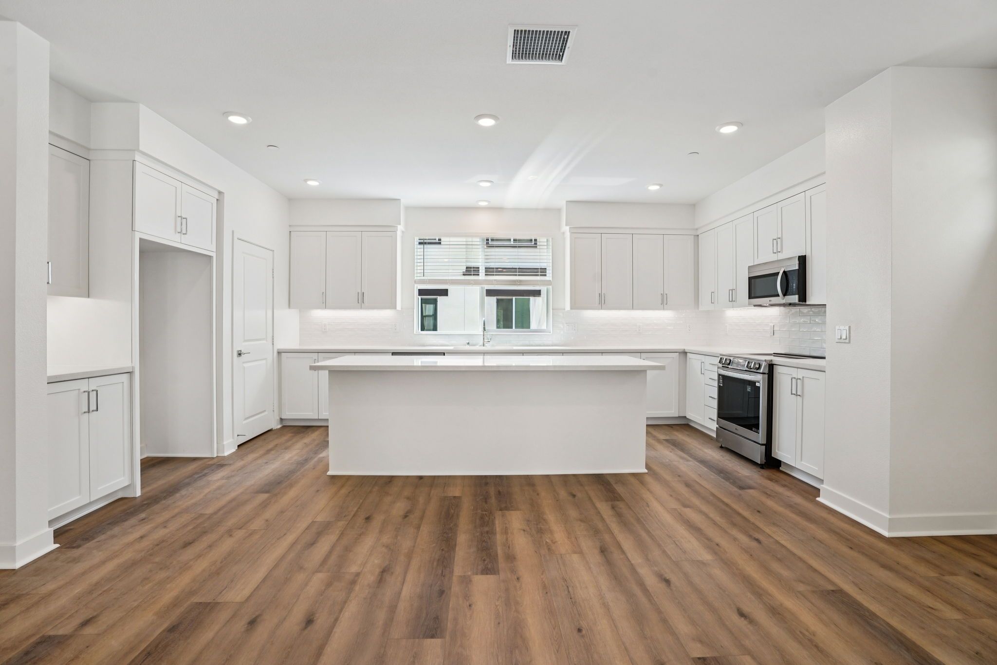 Kitchen with upgraded quartz, backsplash, and spacious island