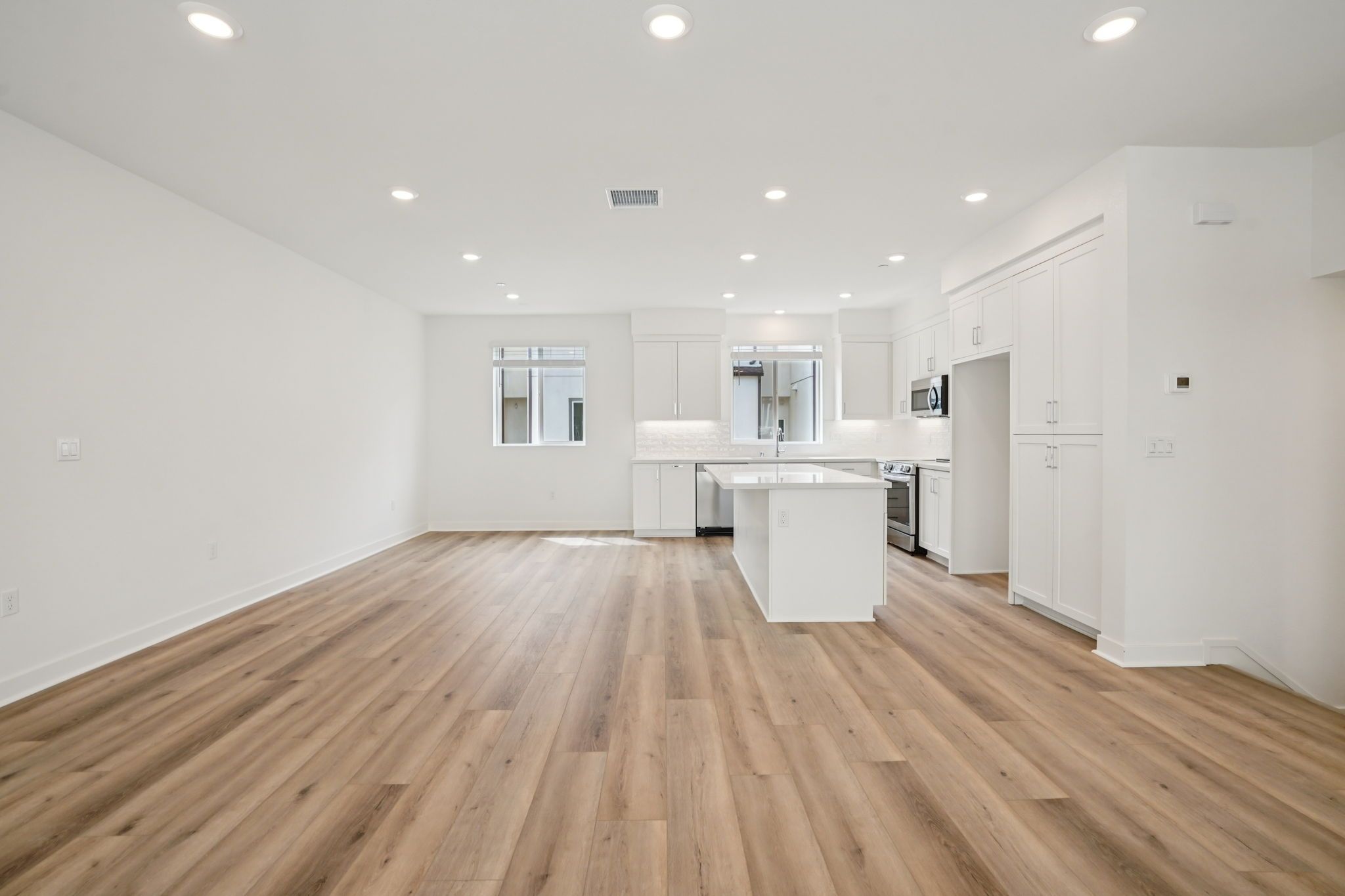 Spacious great room with upgraded flooring, window treatments, and stunning deck