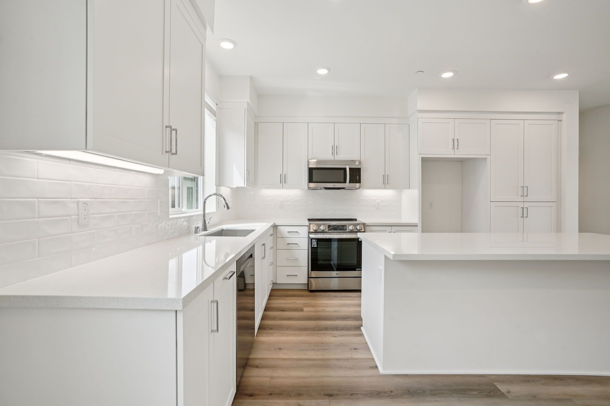 Open-concept kitchen with quartz counters and large island