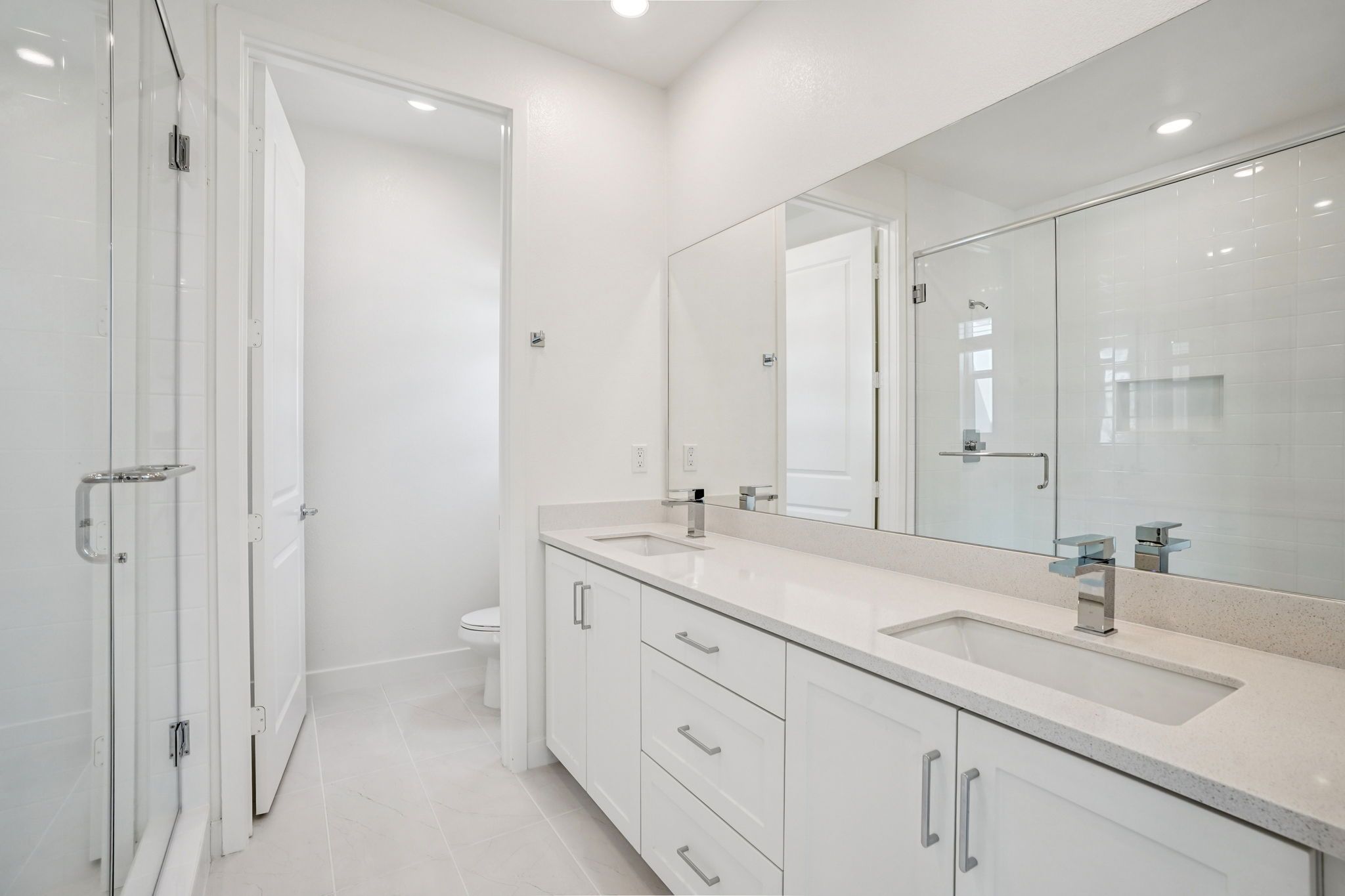 Primary bathroom featuring a double vanity and shower