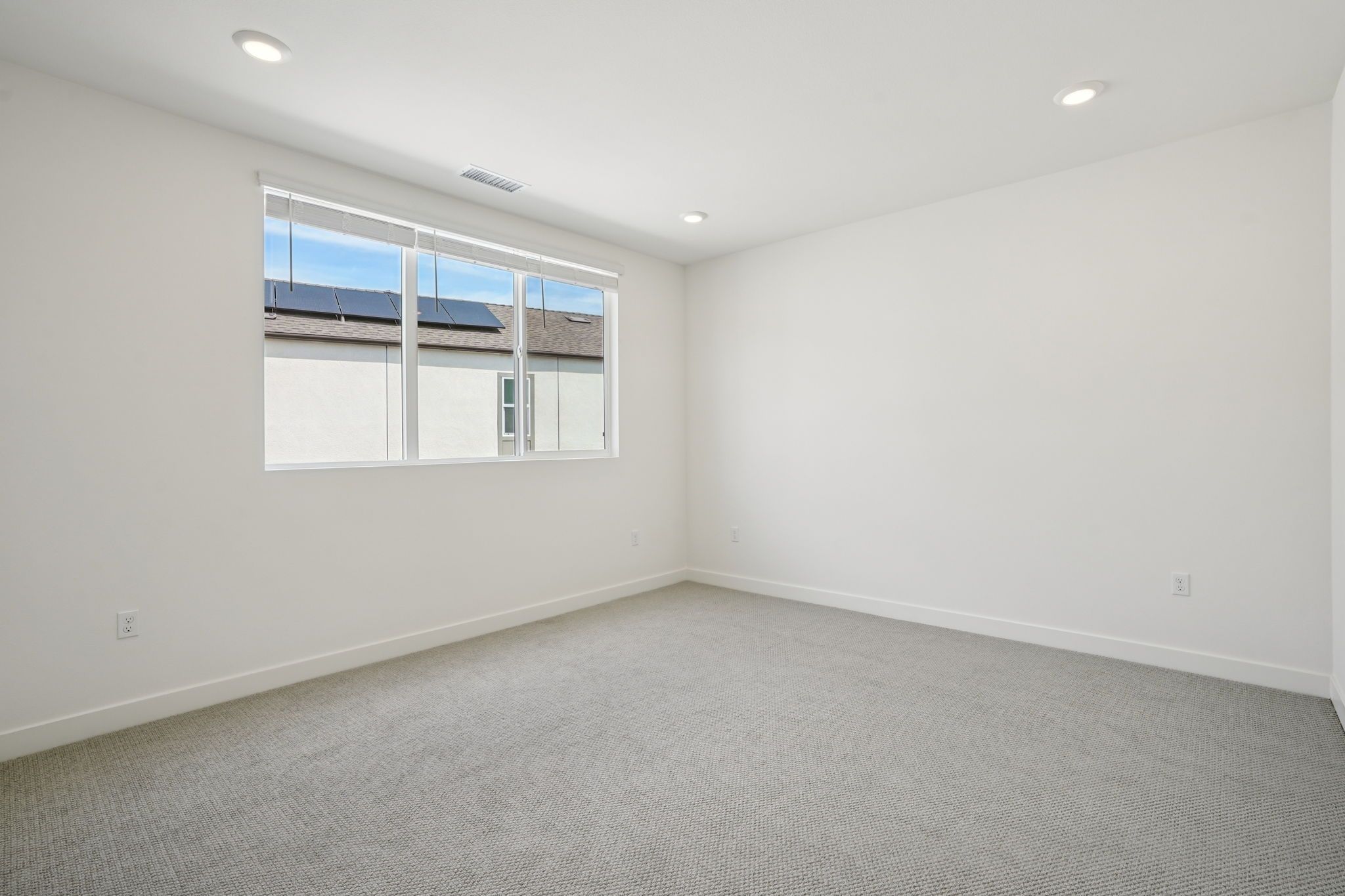 Open primary bedroom with a bright, tall window