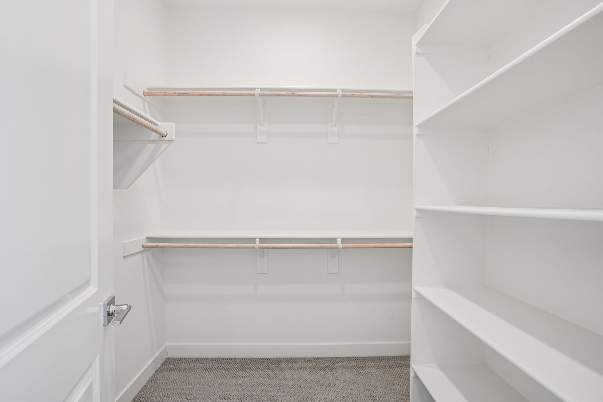Large primary walk-in closet with ample shelving and hanging space.