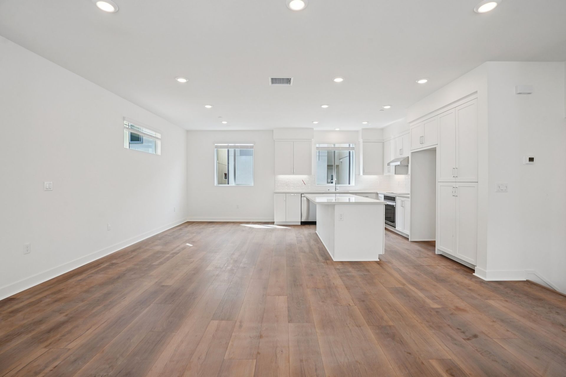 Spacious great room with upgraded flooring, window treatments, and stunning deck