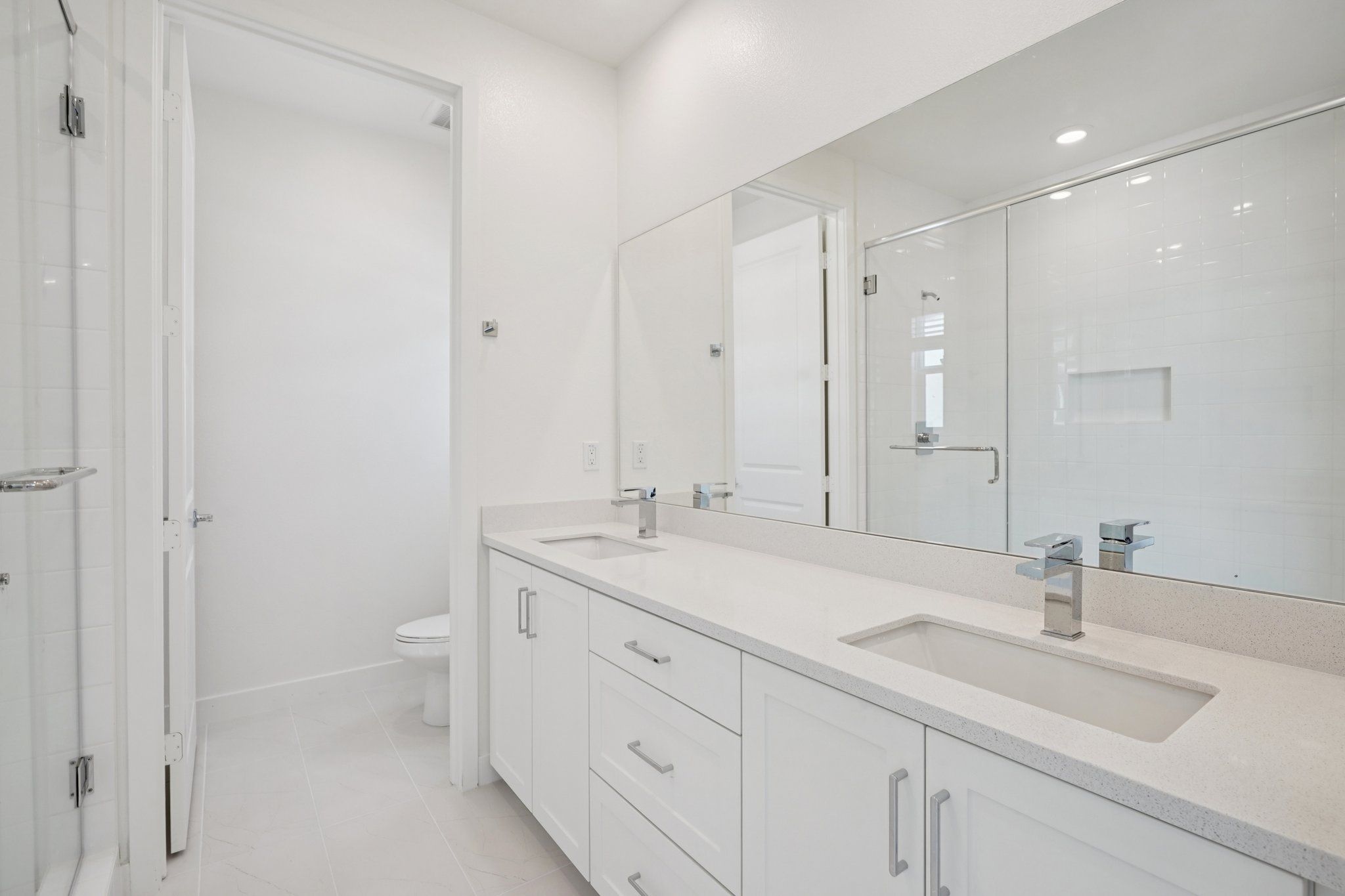 Primary bathroom featuring a double vanity and shower