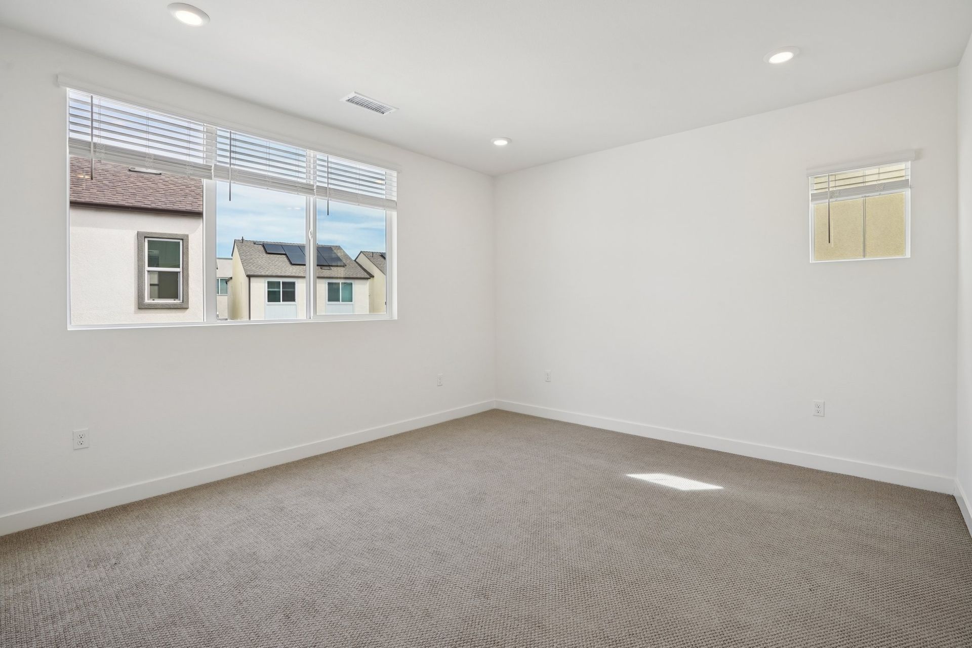 Open primary bedroom with a bright, tall window