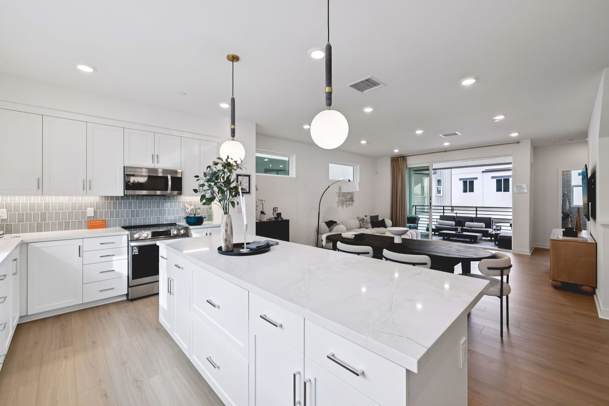 Model home great room featuring an open layout for kitchen, dining, and living.