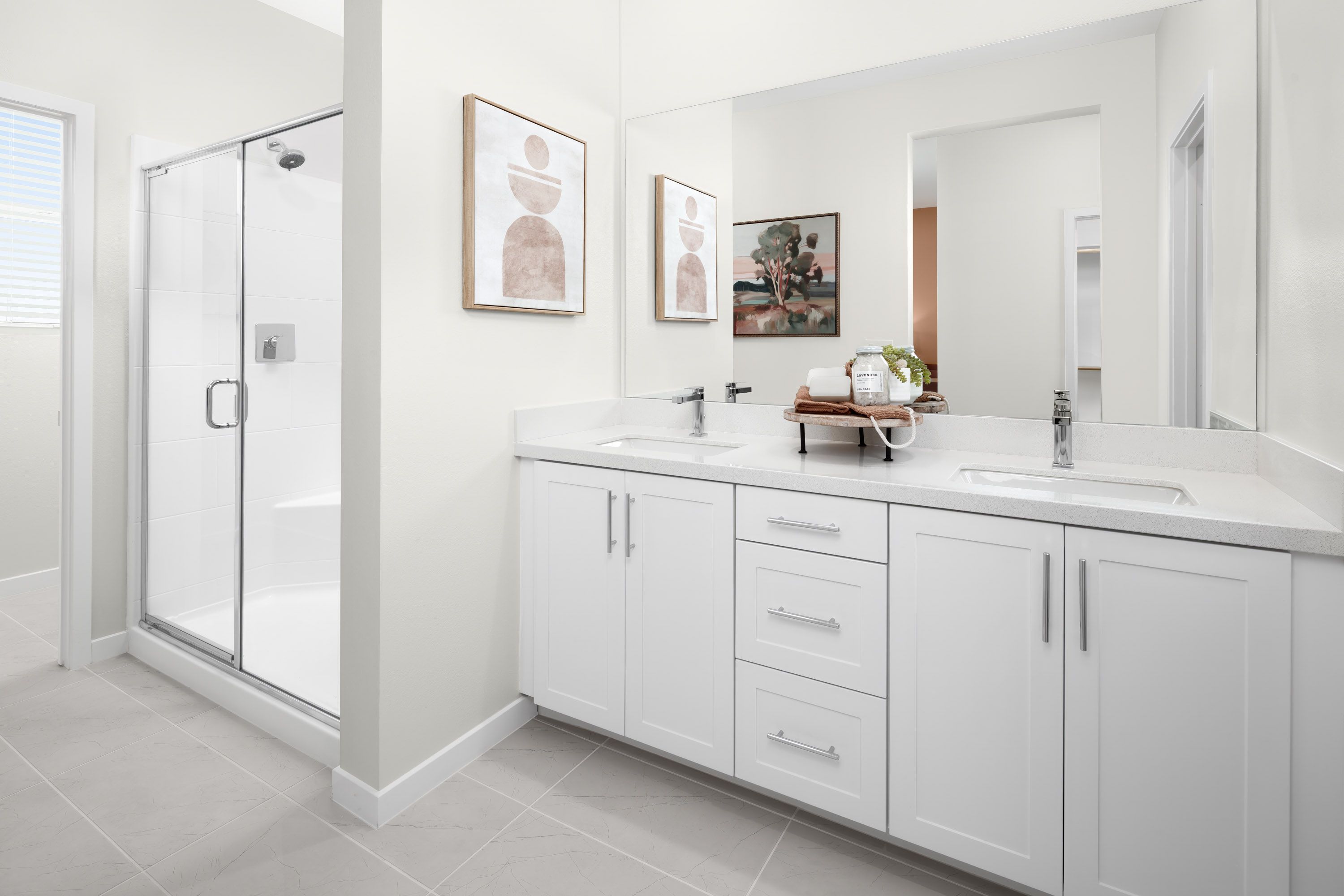 Plan 1 model home primary bathroom featuring a dual vanity and separate shower.
