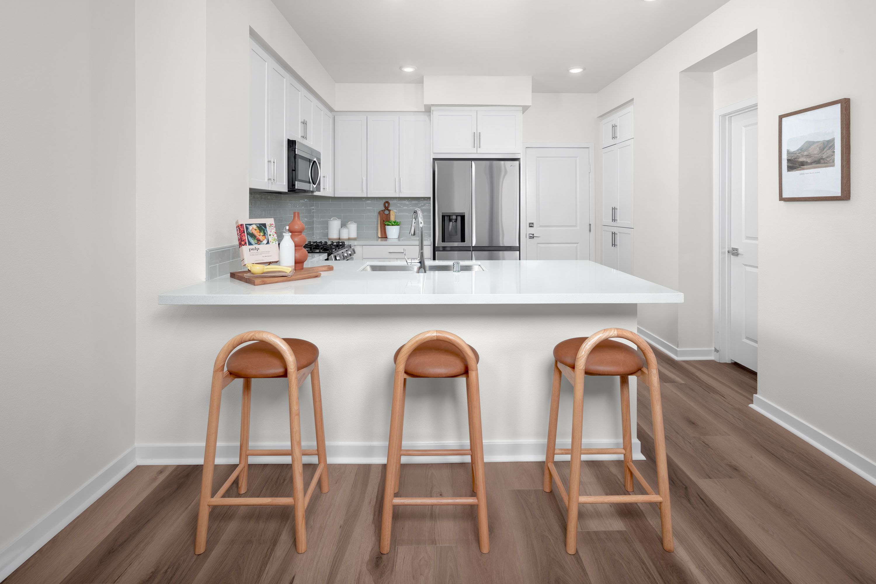 Plan 1 model home kitchen with quartz counter and a spacious peninsula for additional seating space
