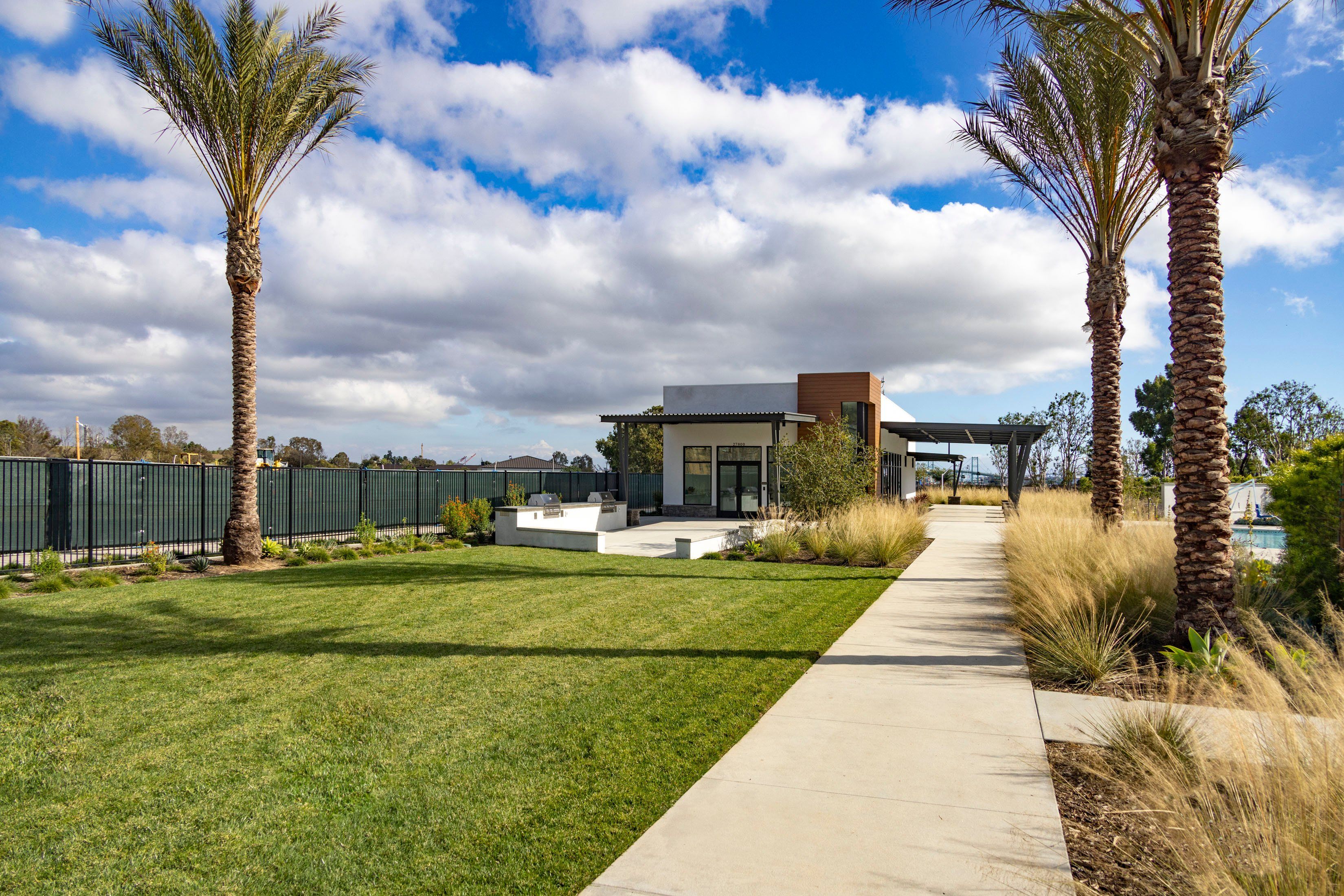 Landscaped Area with Palm Trees and View of Pool House