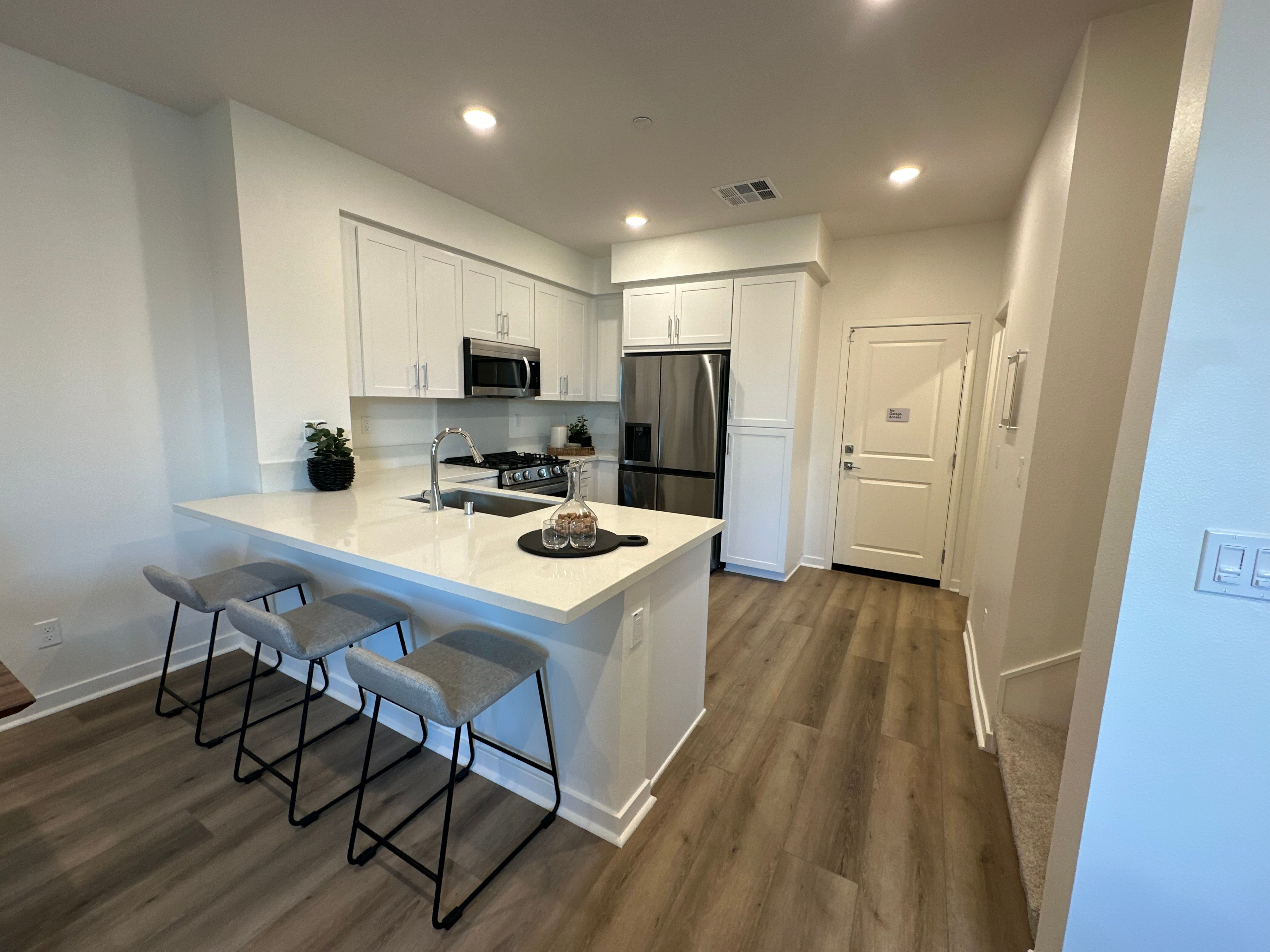 Plan 2 model home kitchen with quartz counter and a spacious peninsula for additional seating space