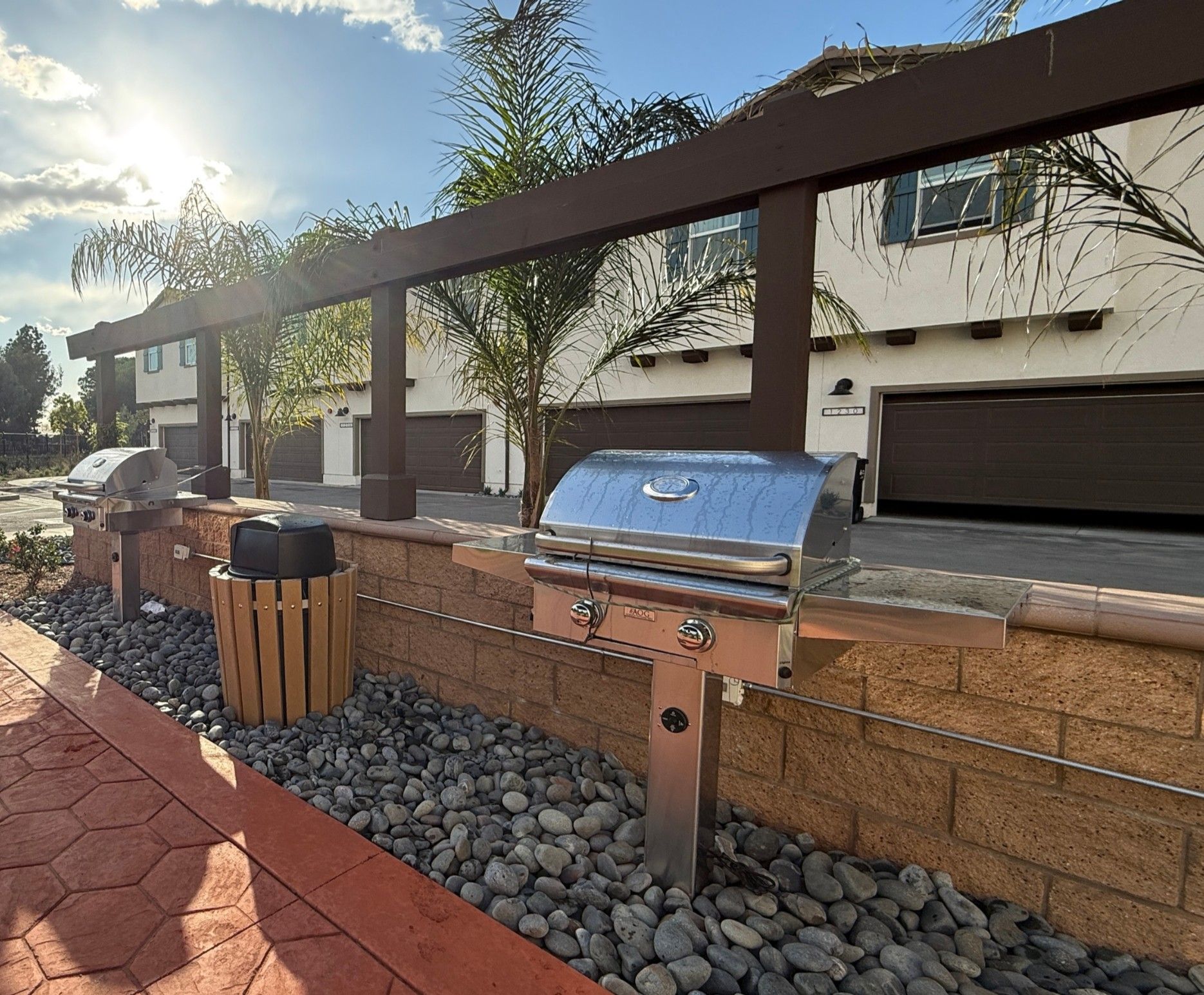 Community barbecue grills in front of common area planter