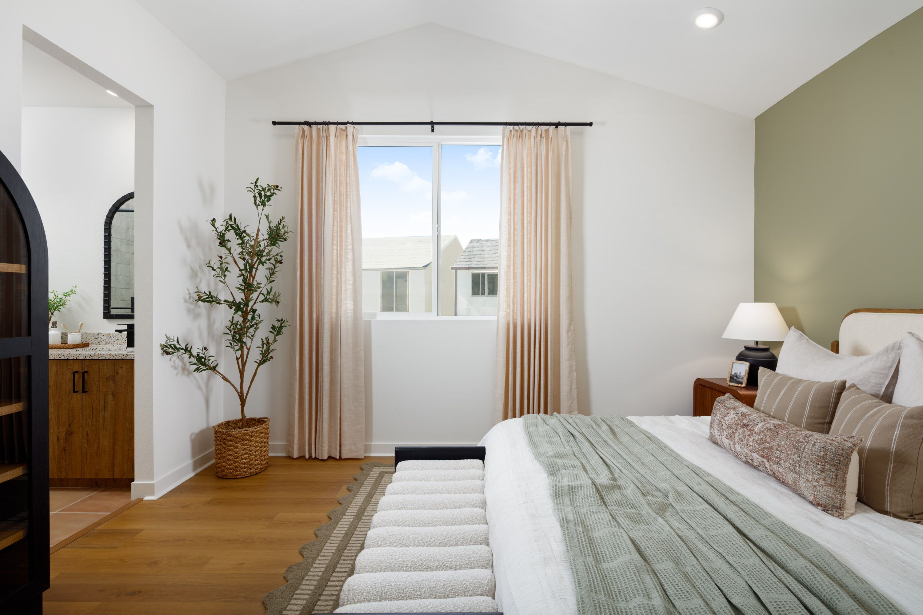 Model home large primary bedroom with en-suite bathroom and vaulted ceilings