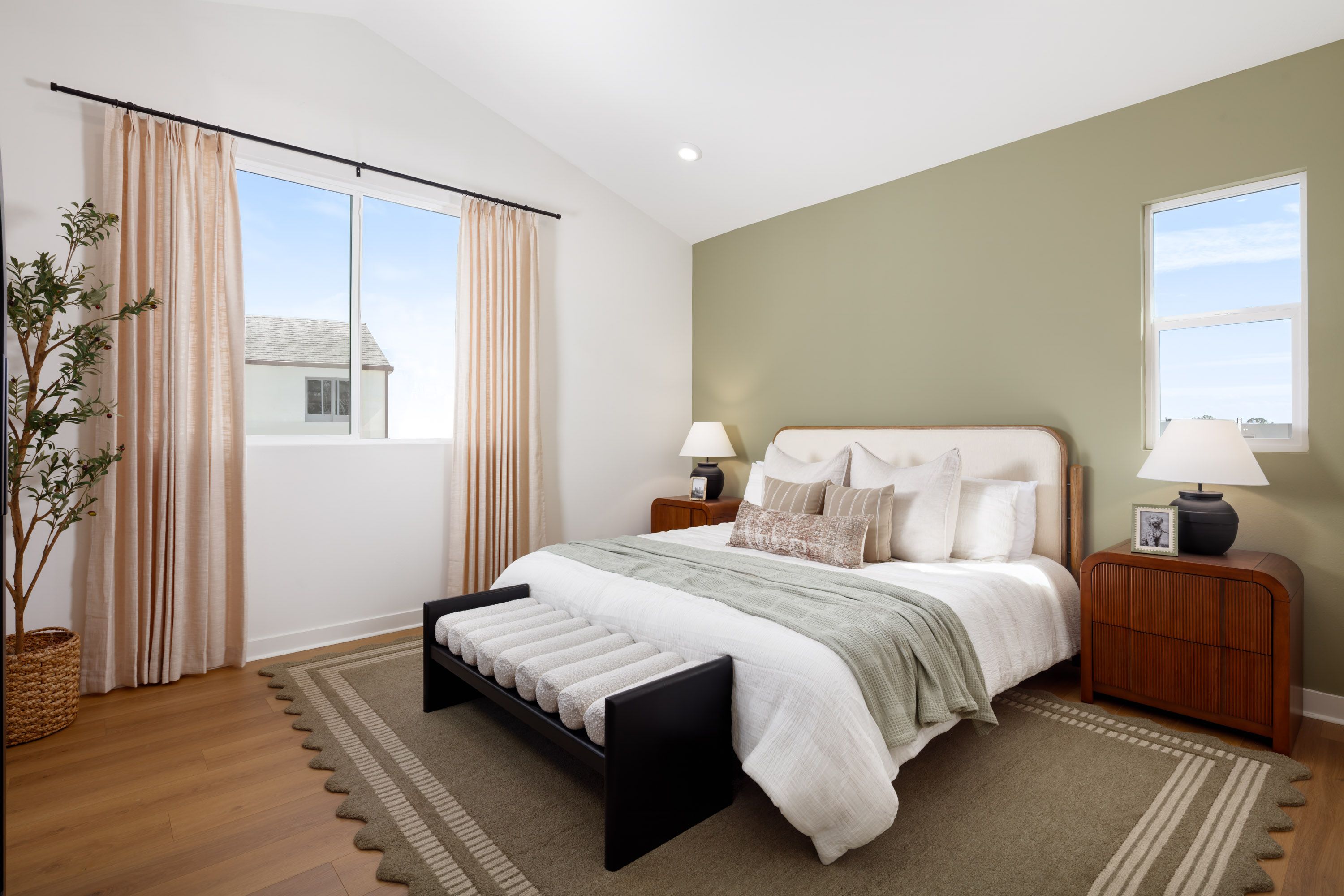 Model home primary bedroom enhanced by a wide window that fills the room with natural daylight.