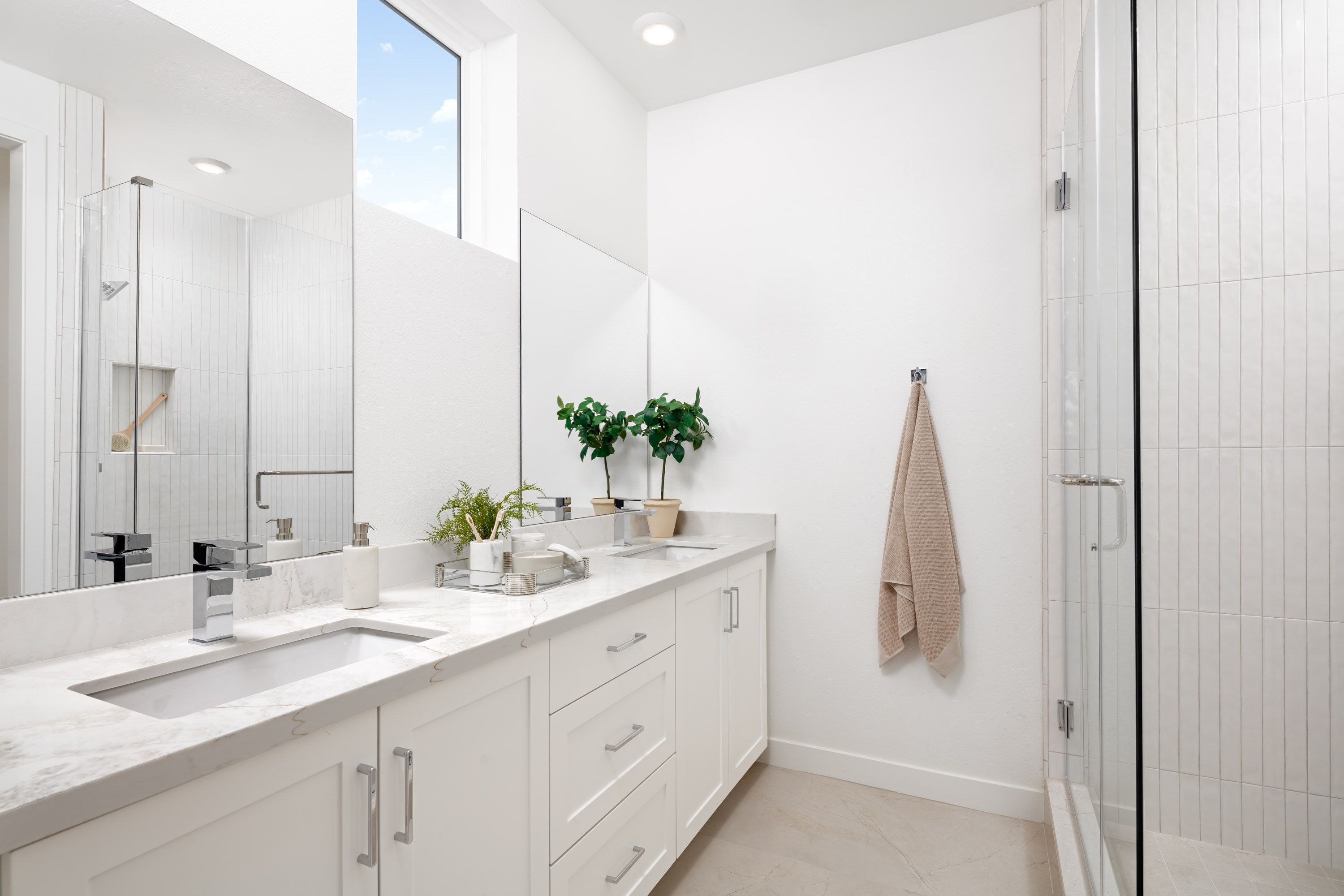 Model home primary bathroom featuring a double vanity and shower