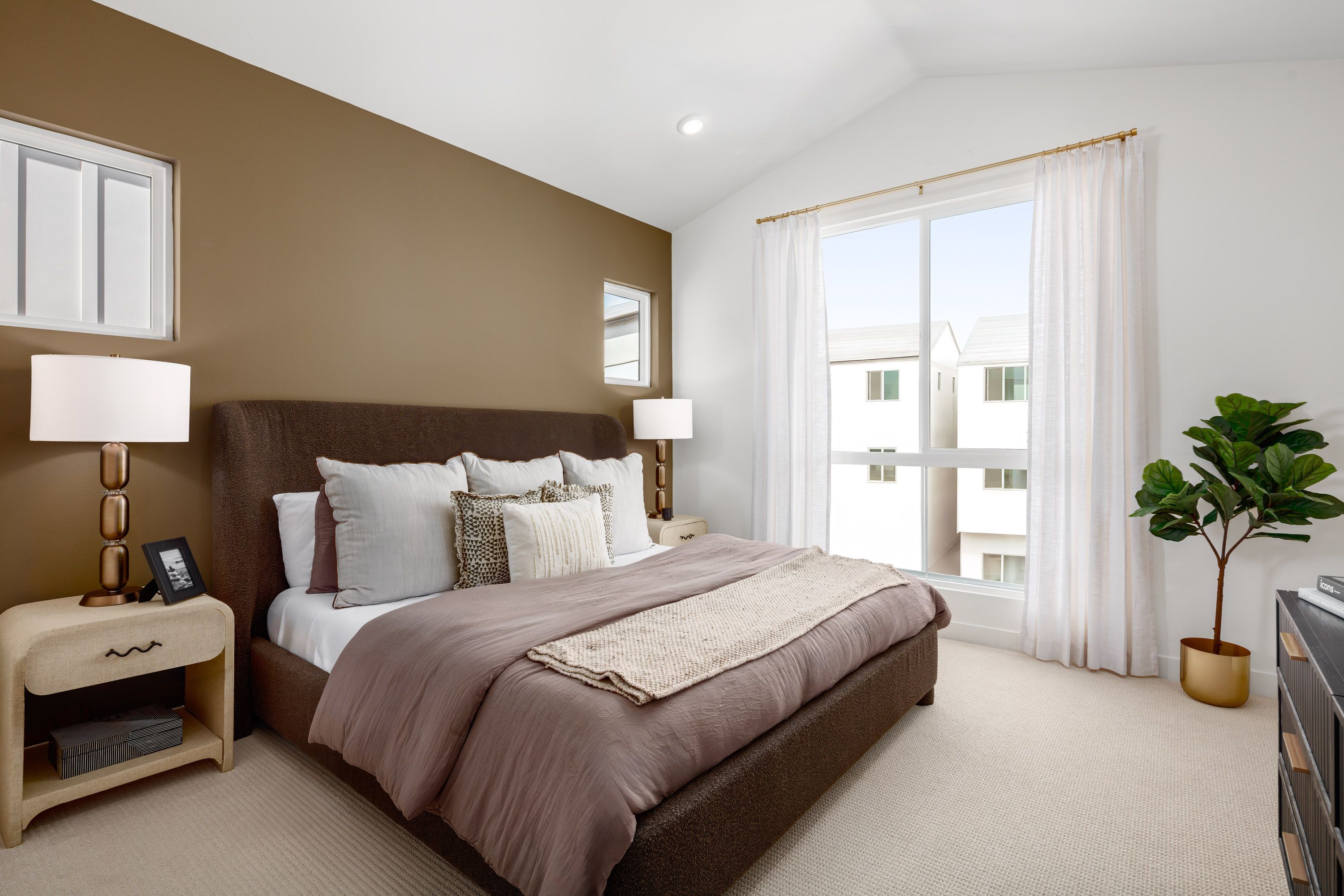 Model home open primary bedroom with a bright, tall window