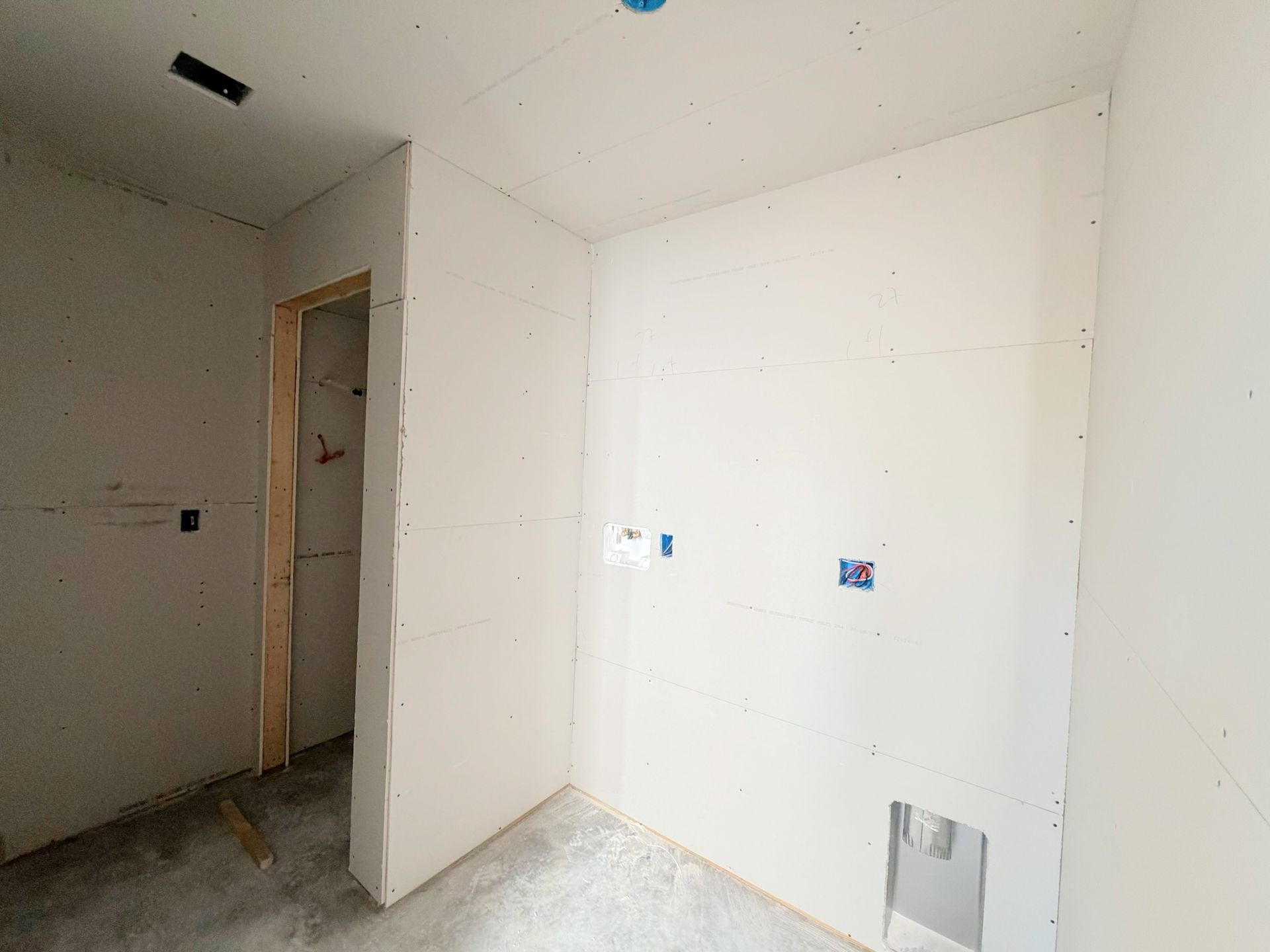 Master bath taking shape with linen closet access and wall surfaces prepared for tile, a designer vanity with cultured marble top and sink.