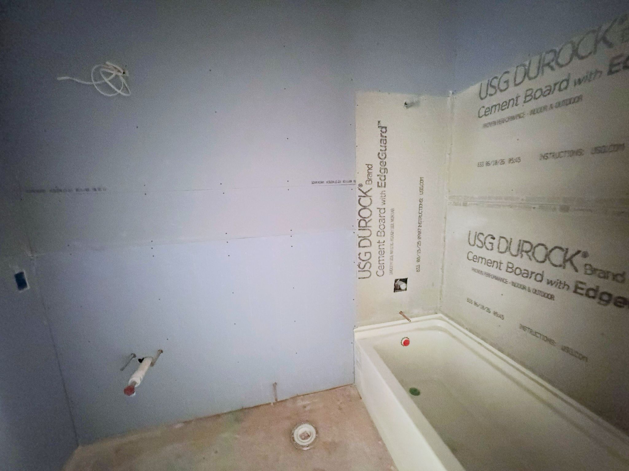 Upper level additional full bathroom space in progress with the tub/shower area installed and surrounding finish work underway.