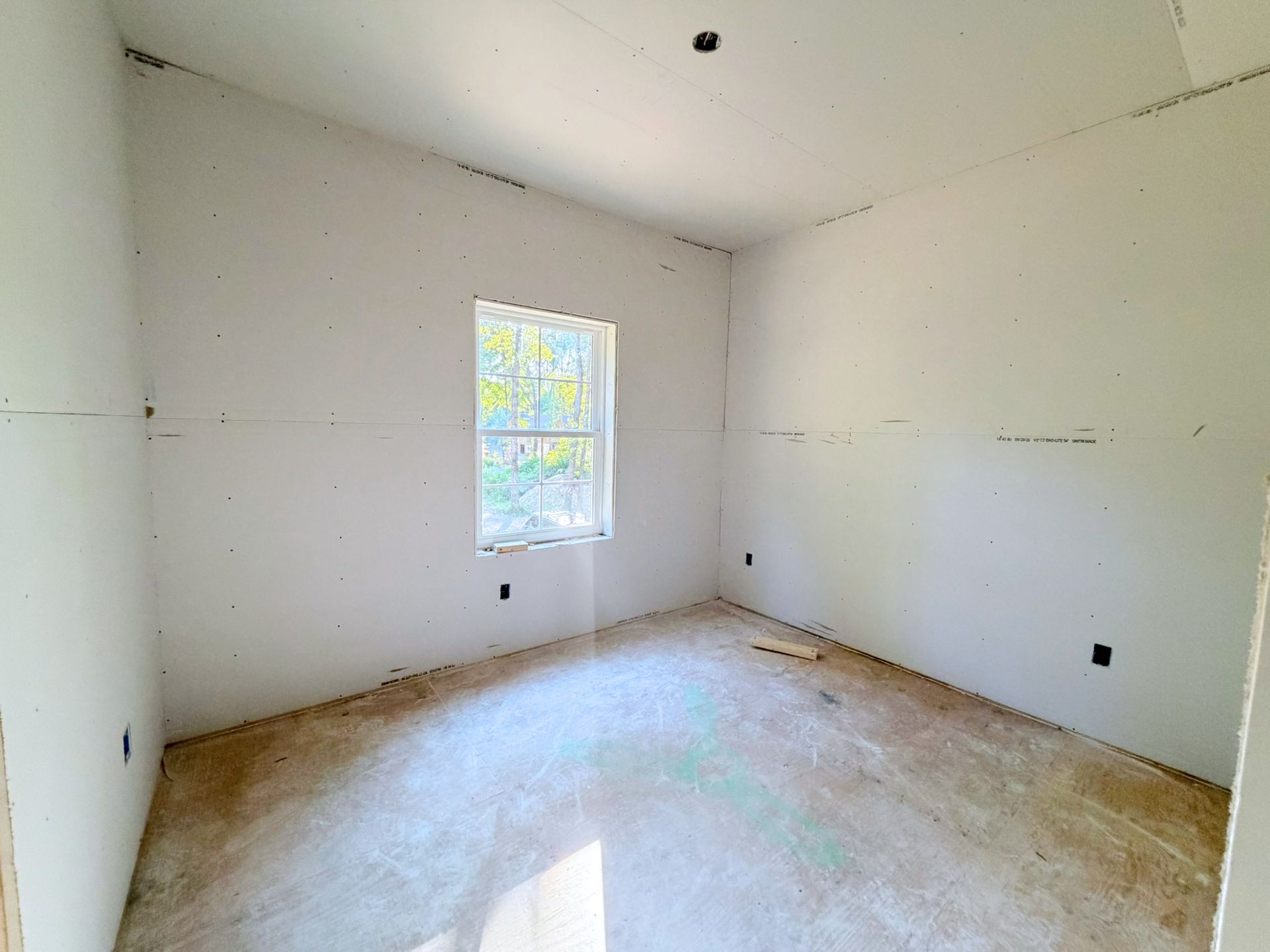 Another bedroom progressing towards completion with finished wall surfaces and window installation in place.