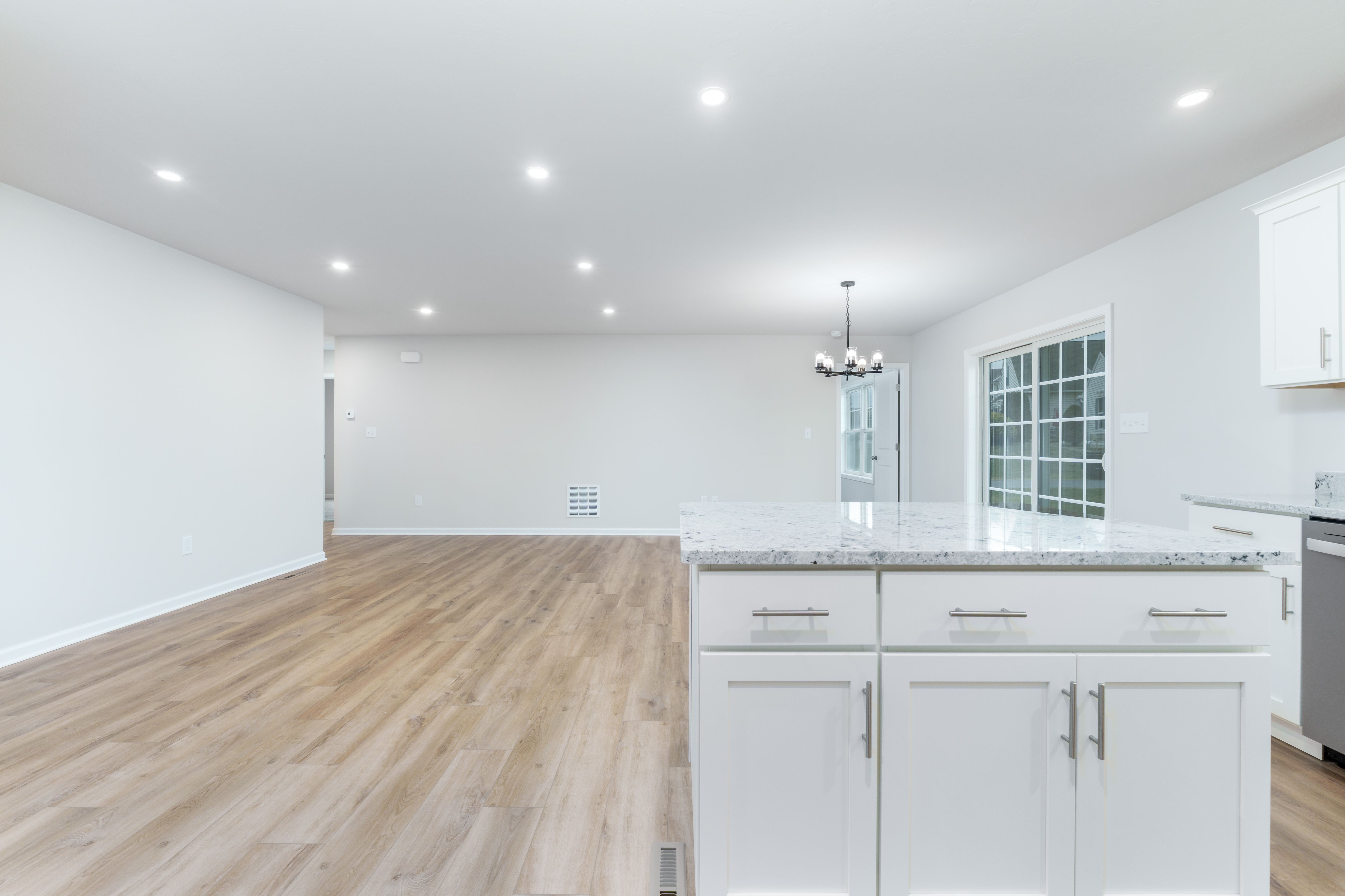 Kitchen island view with luxury vinyl plank flooring, sliding glass door, and recessed lighting throughout