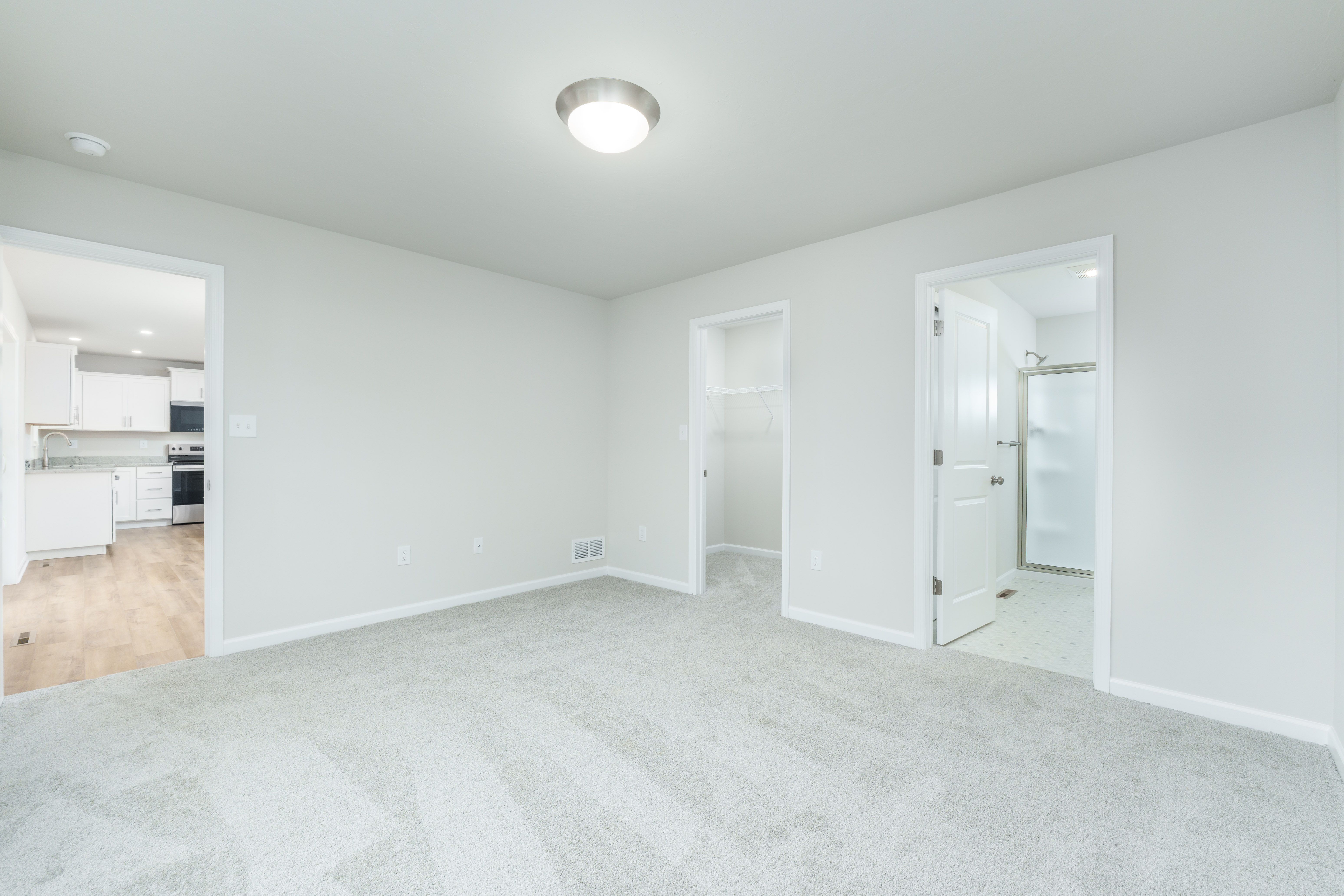 Owners bedroom with large window, carpeted flooring, and neutral wall colors